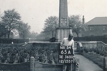 Hoyland War Memorial and gardens with a man in front holding an information board and pointer arrow