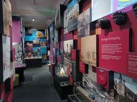 Experience Barnsley Museum main gallery. A display showing 'An age of industry' and other information boards not legible.