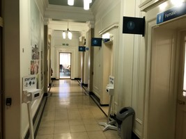 Corridor and entrances to female, male and accessible toilets on the right.