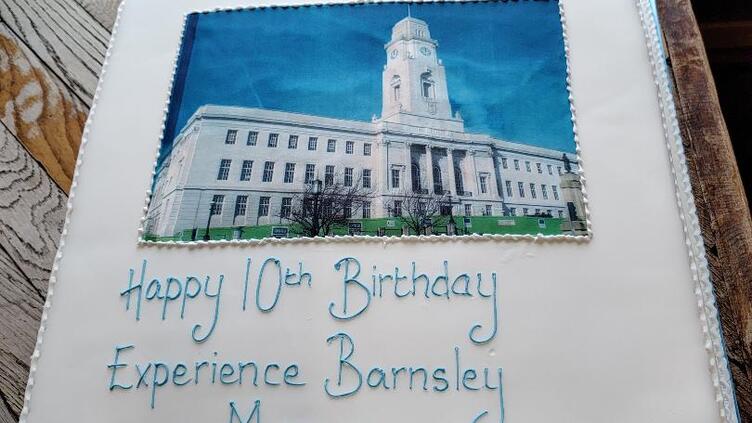 Birthday cake saying 'Happy 10th Birthday Experience Barnsley Museum' with a picture of the Town Hall on the front