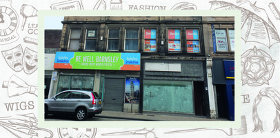 Two empty shops, one has a sign for Be Well Barnsley, the other shop sign has been removed.