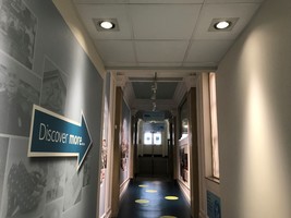 Corridor leading to Barnsley Archives with a 'discover more' sign in the shape of an arrow on the wall.