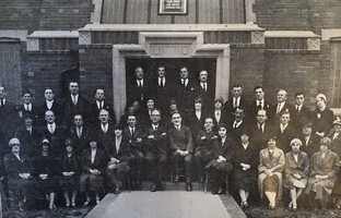 Group of smartly dressed people, some seated others standing outside the entrance to Lundwood Wesleyan Methodist Church.