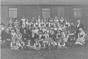 Group of people dressed in costumes outside Carlton Welsh Chapel, which is made of corrugated iron 