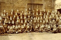 A school photograph of teachers and pupils taken outside in front of a building